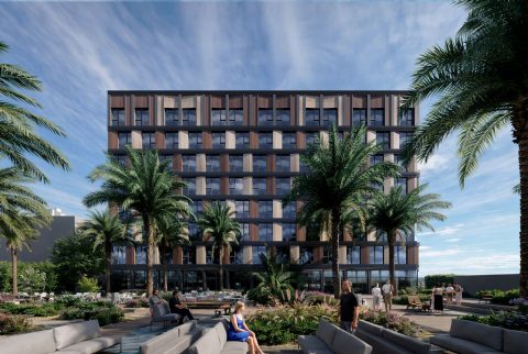 Fachada de hotel con paneles de madera intercalados y espacio ajardinado delante